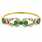 Gold tennis bracelet with alternating emerald and diamond oval stations, bezel-set green stones