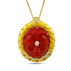 Close-up of carved coral face pendant with diamond details in a gold setting