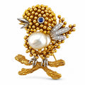 Gold-tone bird brooch with pearl center, sapphire eye, diamond accents and beaded body