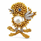 Gold-tone bird brooch with pearl center, sapphire eye, diamond accents and beaded body