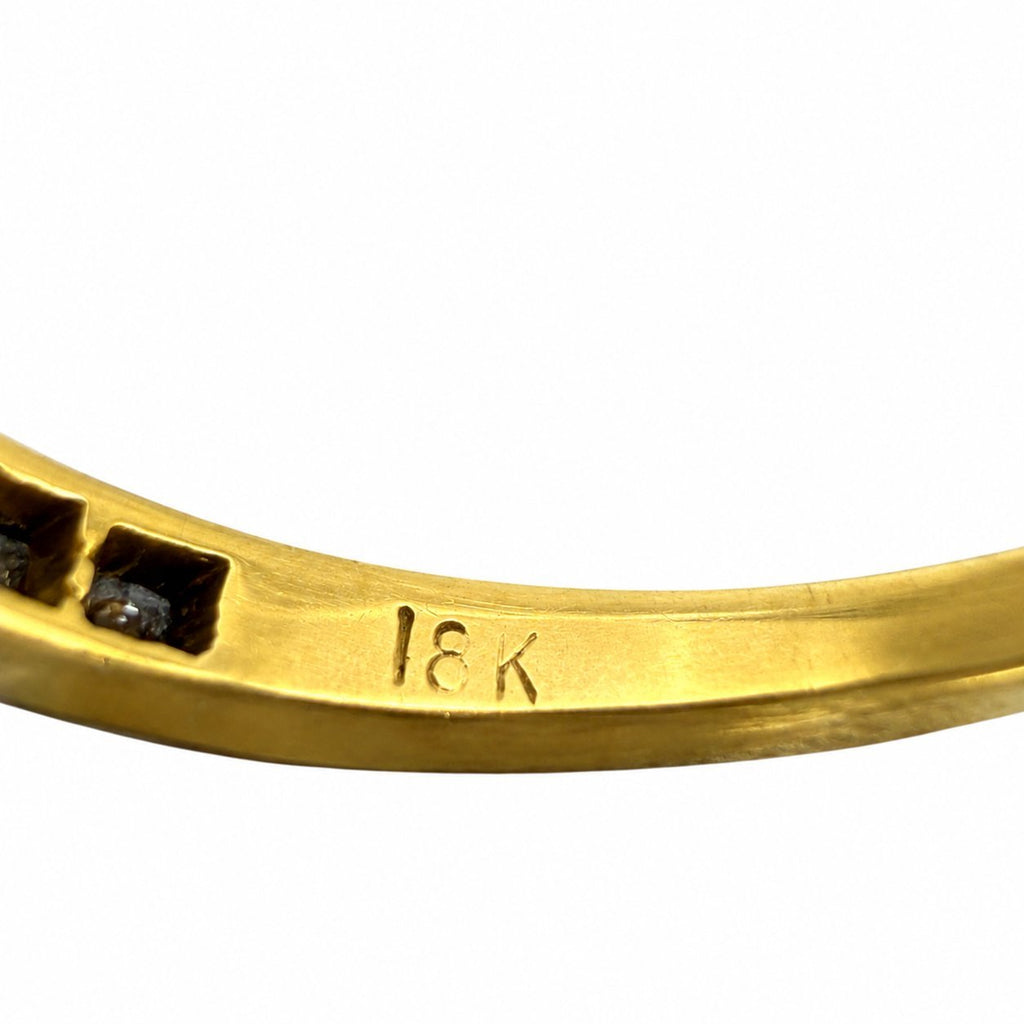 18K yellow gold band with '18K' engraving and blue sapphire setting