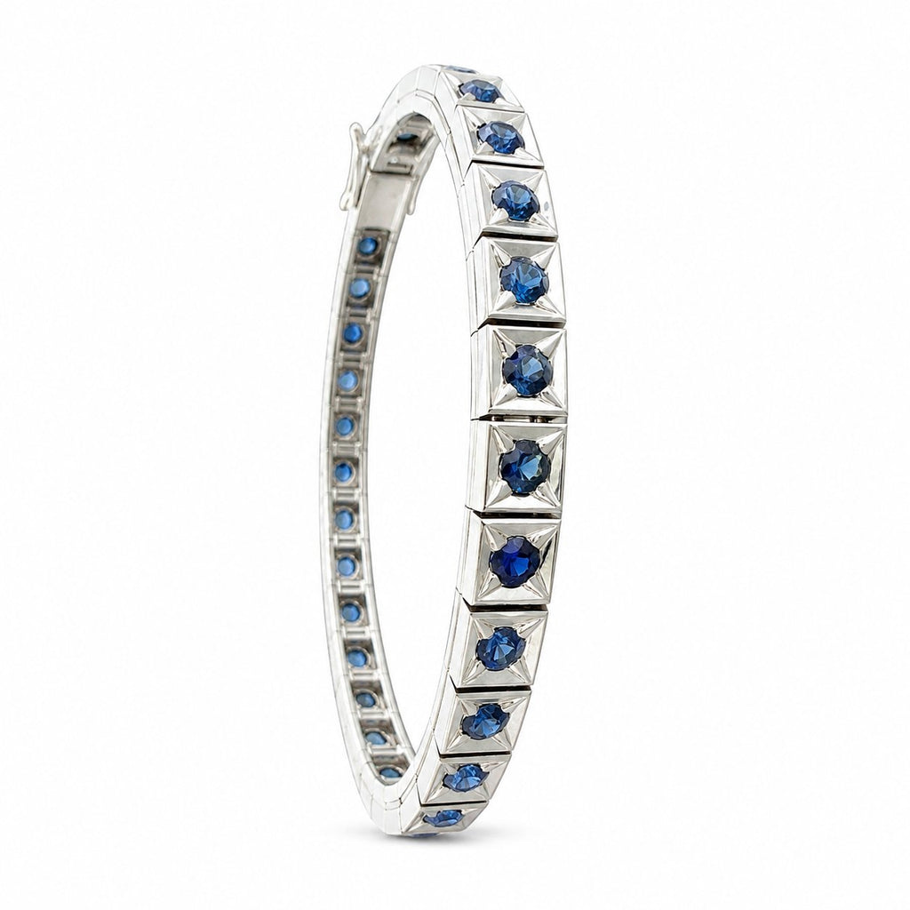 Platinum sapphire tennis bracelet side view with faceted blue stones in bezel settings