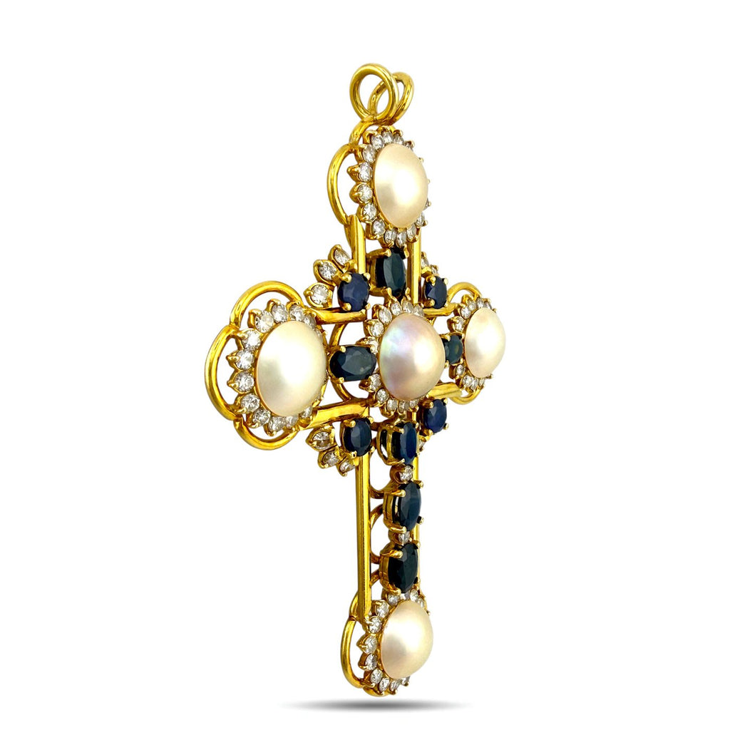 Side view gold cross pendant with pearls, blue sapphires, and diamond accents