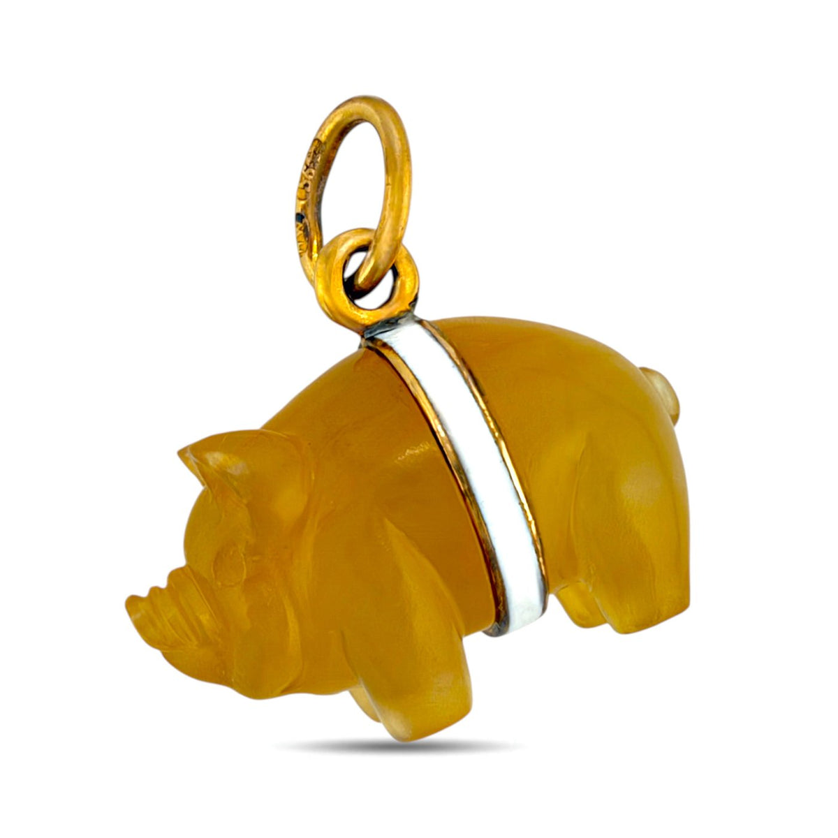 Close-up side view of the amber-colored pig pendant with a white enamel band.