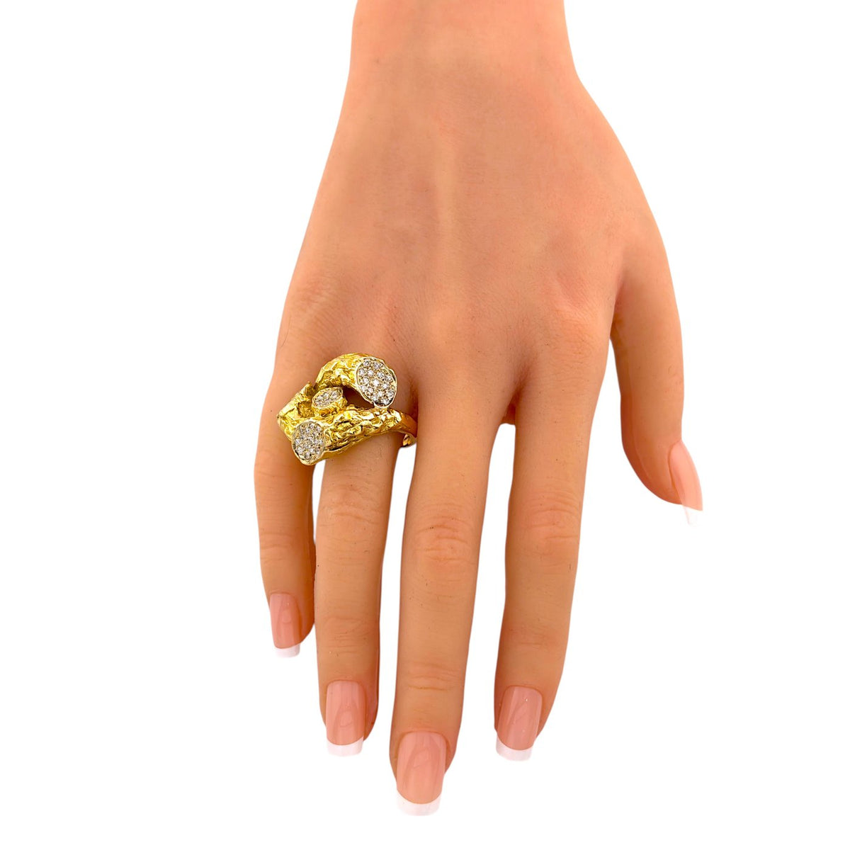 Yellow gold diamond ring shown on a hand, with a raised branch-like setting