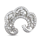 18K white gold diamond swirl brooch with baguette and round stones, open frame.