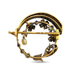 Back of the brooch showing its gold pin, clasp, and openwork floral setting