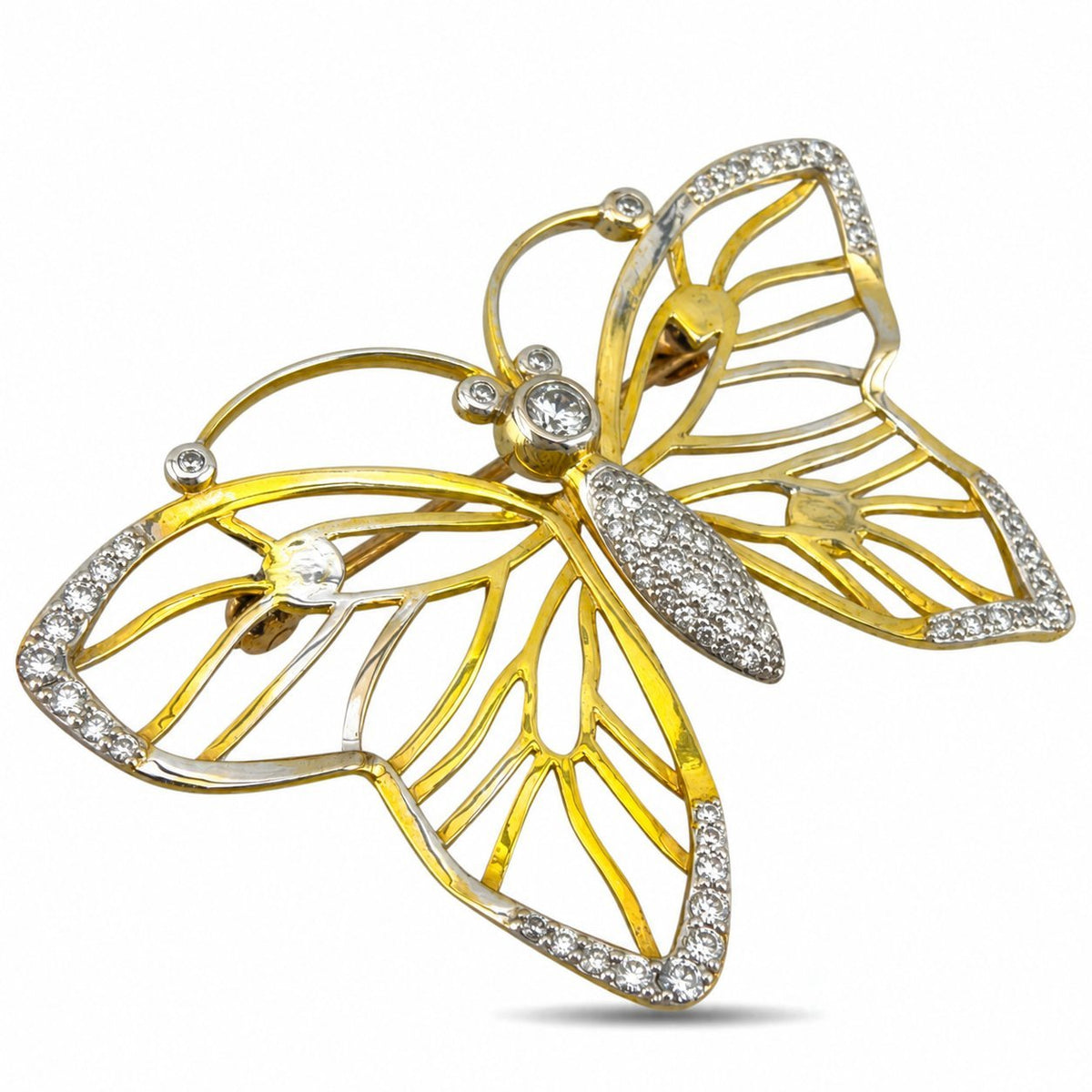 Openwork butterfly brooch in tri-color gold with diamond-set wings and body, shown at an angle