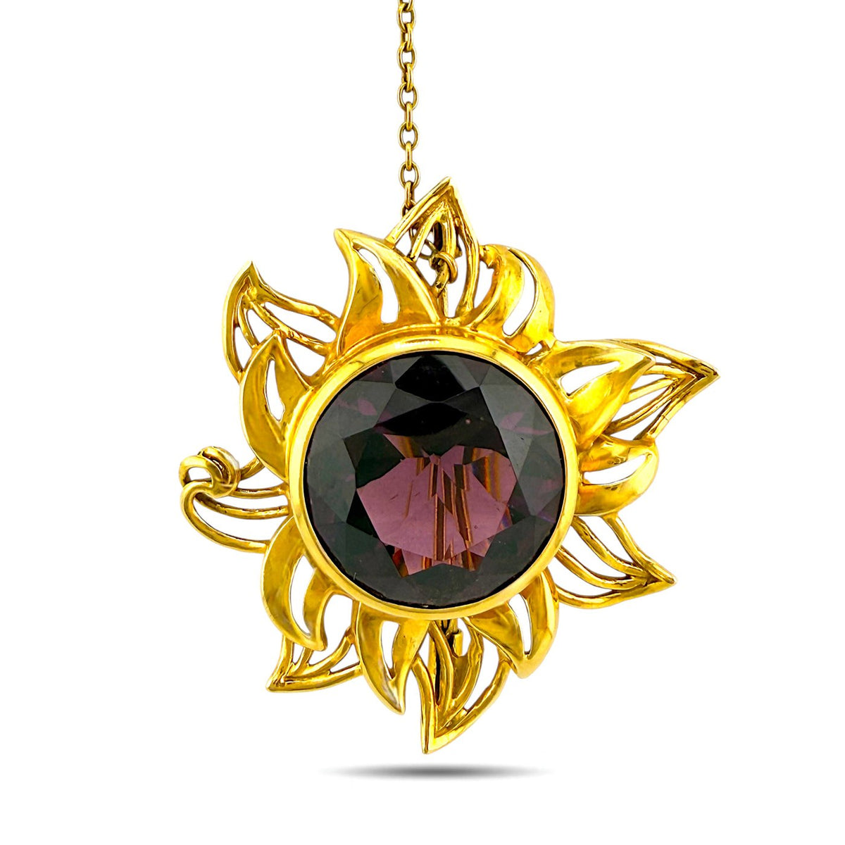 Gold sunburst brooch with large round dark amethyst center, faceted