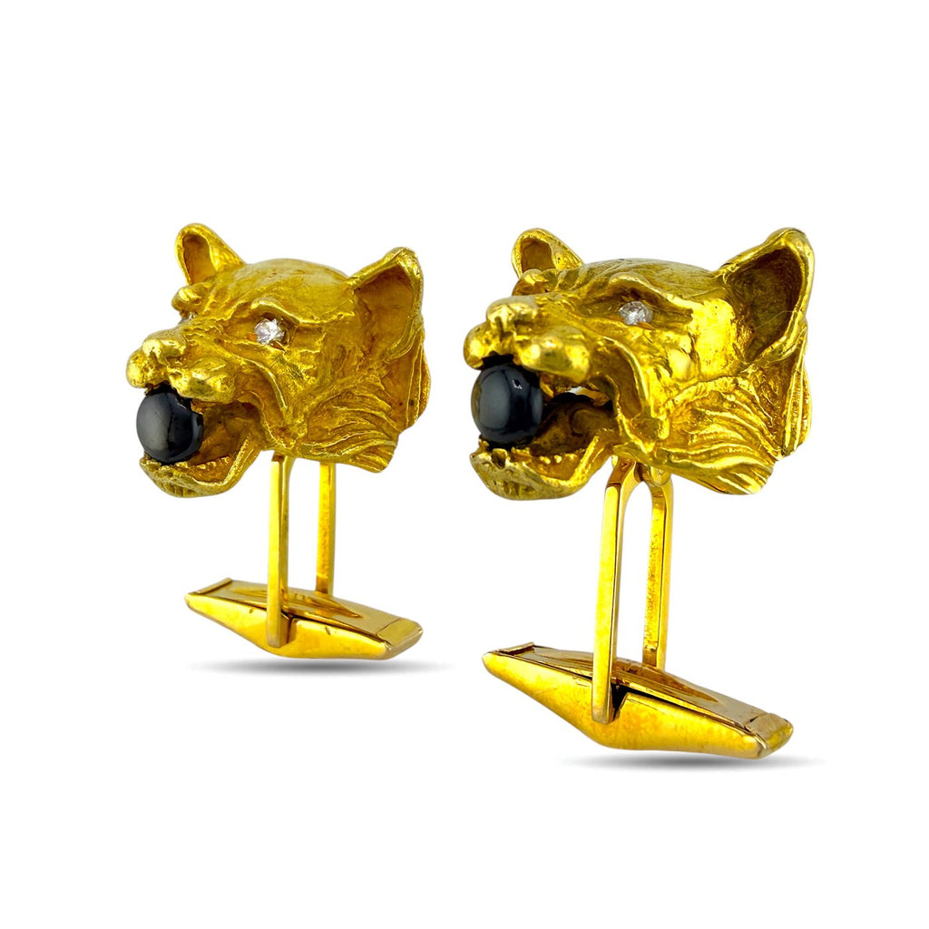 Pair of gold panther cufflinks showing dark stone eyes and small diamond accents, front view