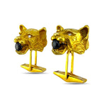 Pair of gold panther cufflinks showing dark stone eyes and small diamond accents, front view