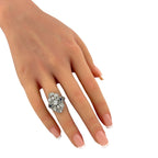 Diamond and sapphire art deco ring worn on finger, with round stones and blue side detail