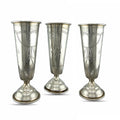 Set of three antique silver cups with engraved panels and flared pedestal bases.