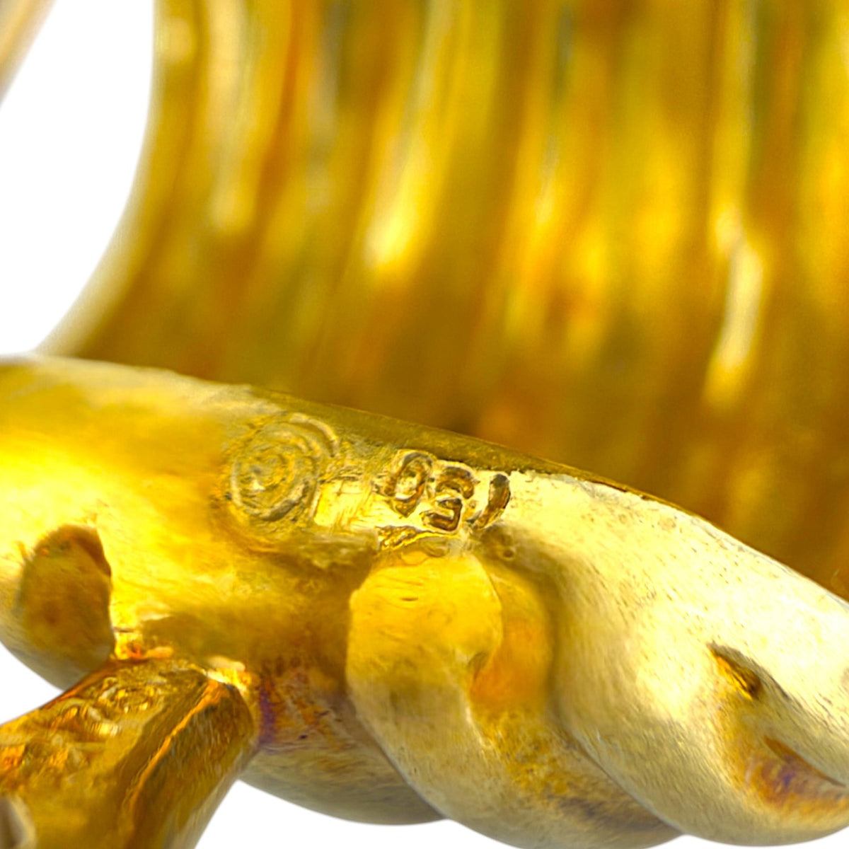 Close-up of a 750 gold purity stamp on a ribbed clip-on earring