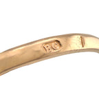 Rose gold ring band underside with hallmark engraving visible