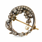 Front view of the floral brooch with diamond flowers, leaf details, and a hanging pearl