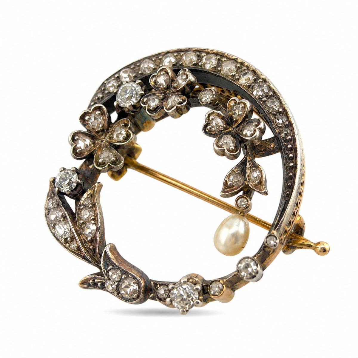 Front view of the floral brooch with diamond flowers, leaf details, and a hanging pearl