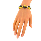 Interlocking gold and black onyx bracelet with diamond accents, worn on the wrist
