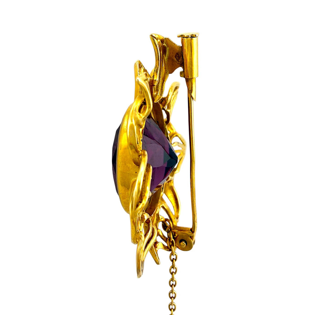 Side view of gold sunburst brooch with dark amethyst center and clasp