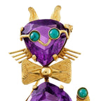 Gold cat brooch showing purple amethyst face with teal turquoise eyes
