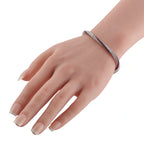 Diamond and ruby snake bracelet on wrist, white metal with pink and clear stone rows