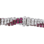 Close-up snake bracelet with white diamonds, ruby stones, and a hinged clasp detail