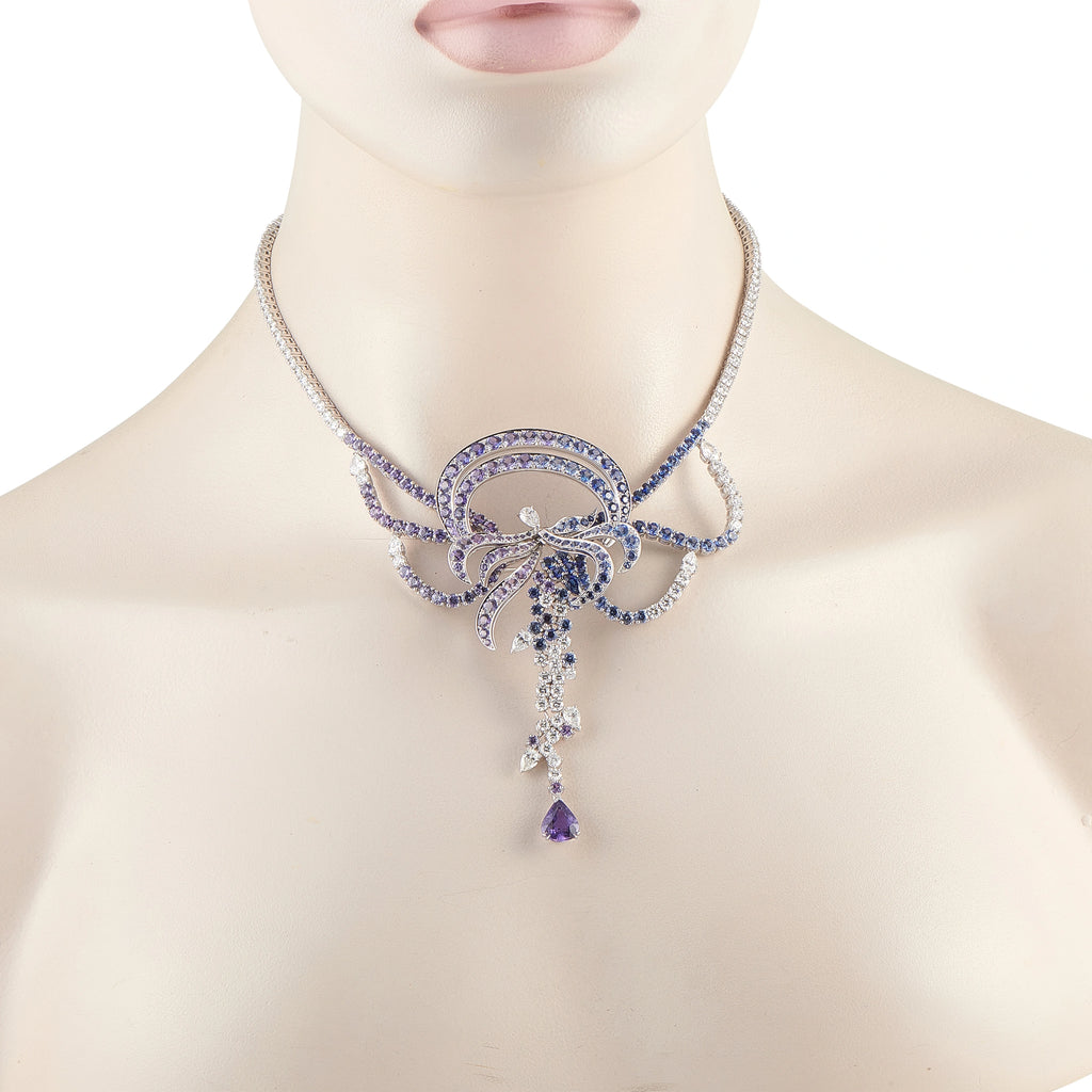Diamond and sapphire necklace on model neck, blue floral pendant with dangling drops