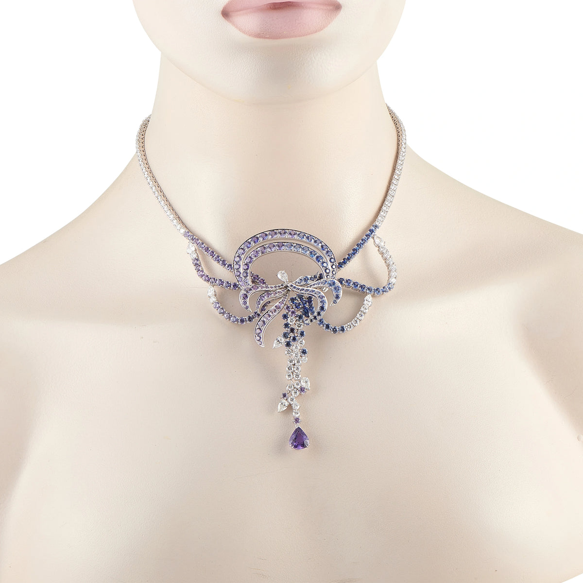 Diamond and sapphire necklace on model neck, blue floral pendant with dangling drops