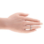 White gold diamond ring on hand, round center stone with square side stones