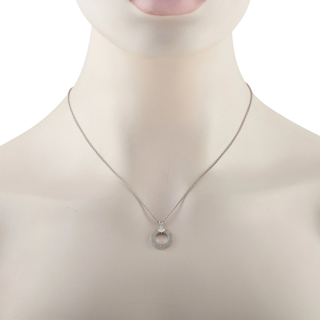 White gold circle diamond pendant on a fine chain worn at the neckline