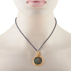 Gold coin pendant with green-blue patina on blue cord necklace