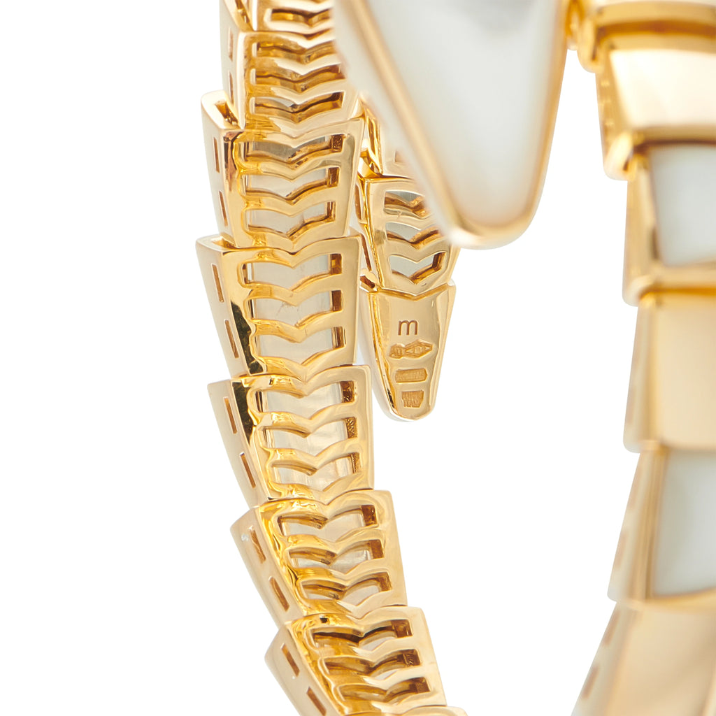Close-up of gold scale-pattern links with mother-of-pearl inlay