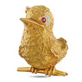 18K yellow gold bird brooch with ruby eye and small diamond accents, front view