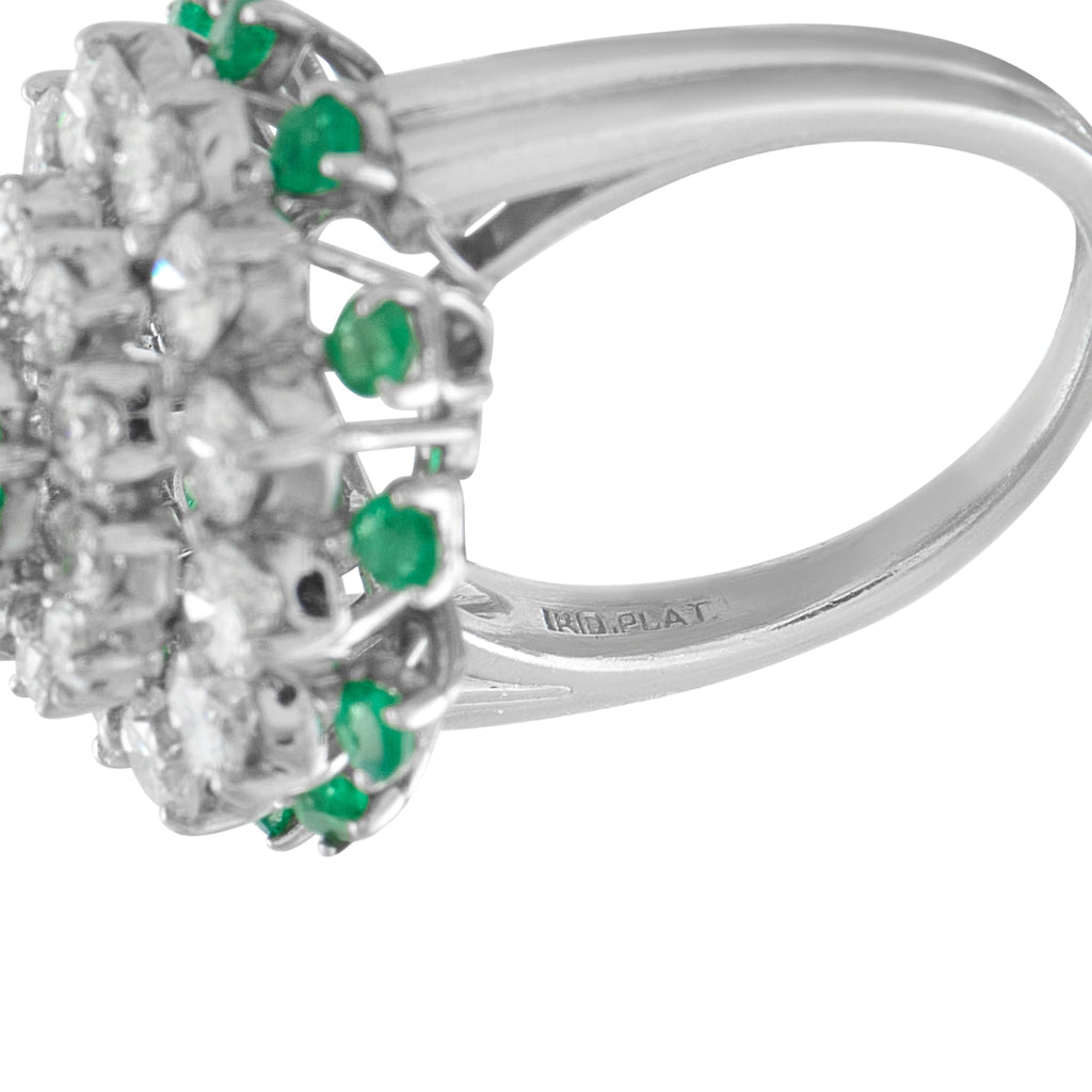 Platinum ring side view showing diamond cluster and small green emerald accents