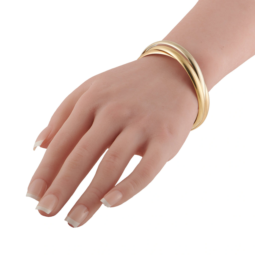 Tri-color 18K gold bangle on hand, polished rose, white, and yellow bands