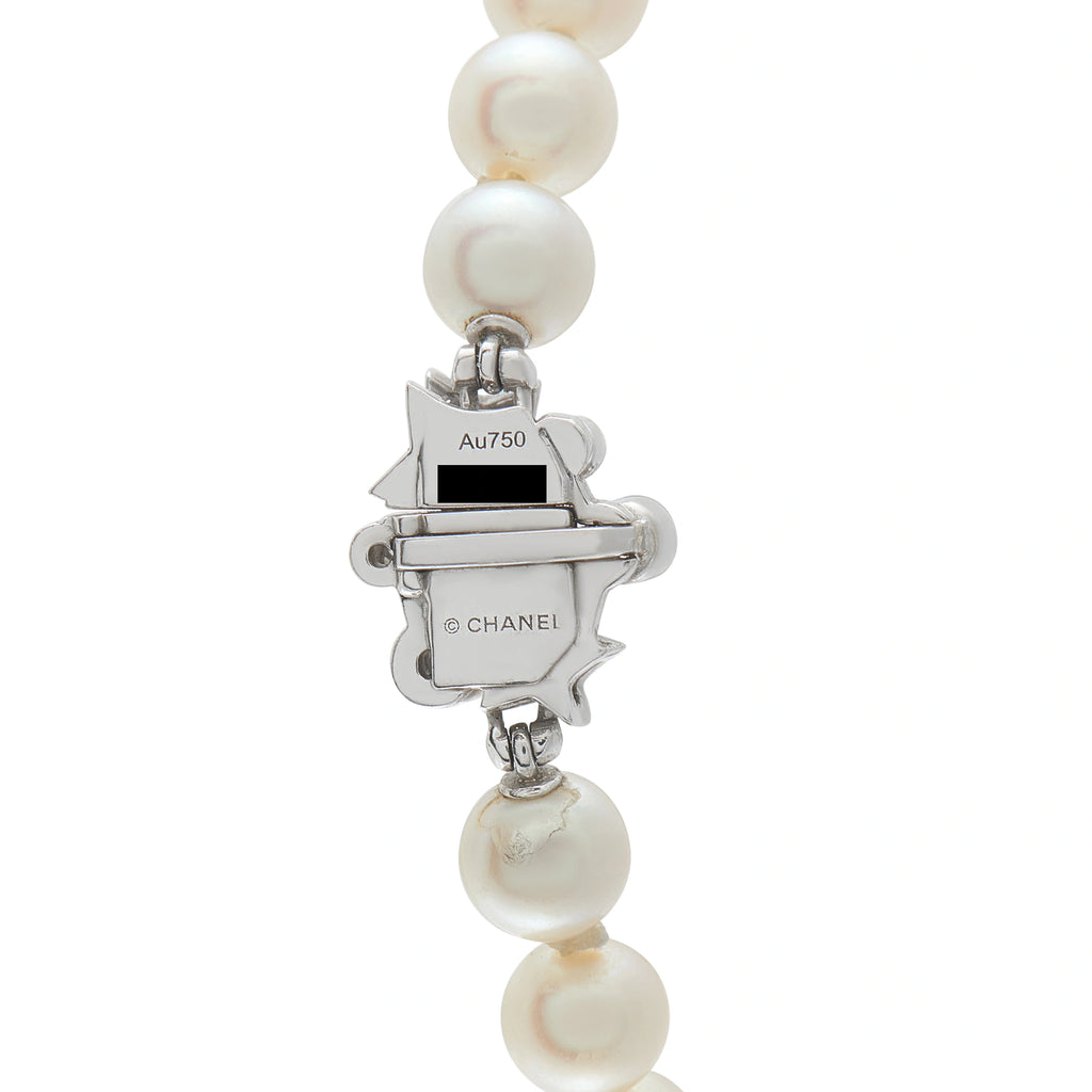 White pearl drop earrings with Chanel logo charm marked Au750 and metal details
