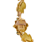 Close-up of 18k yellow gold foliage link with colored stones and engraved hallmark
