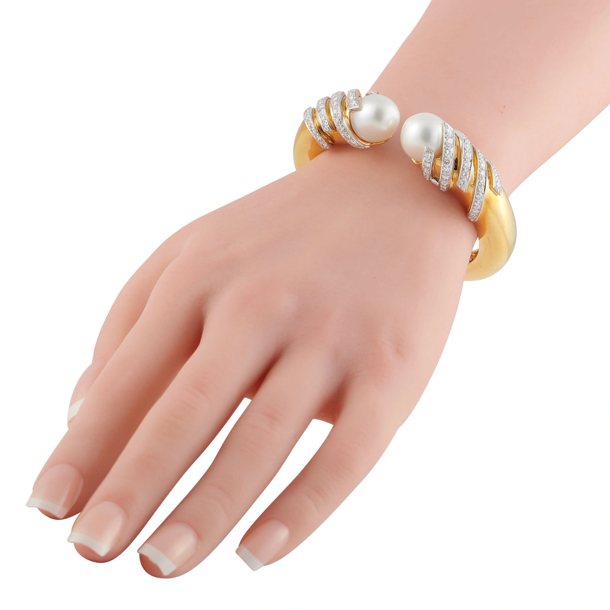 Yellow gold bangle bracelet with diamond rows and two white pearls on wrist