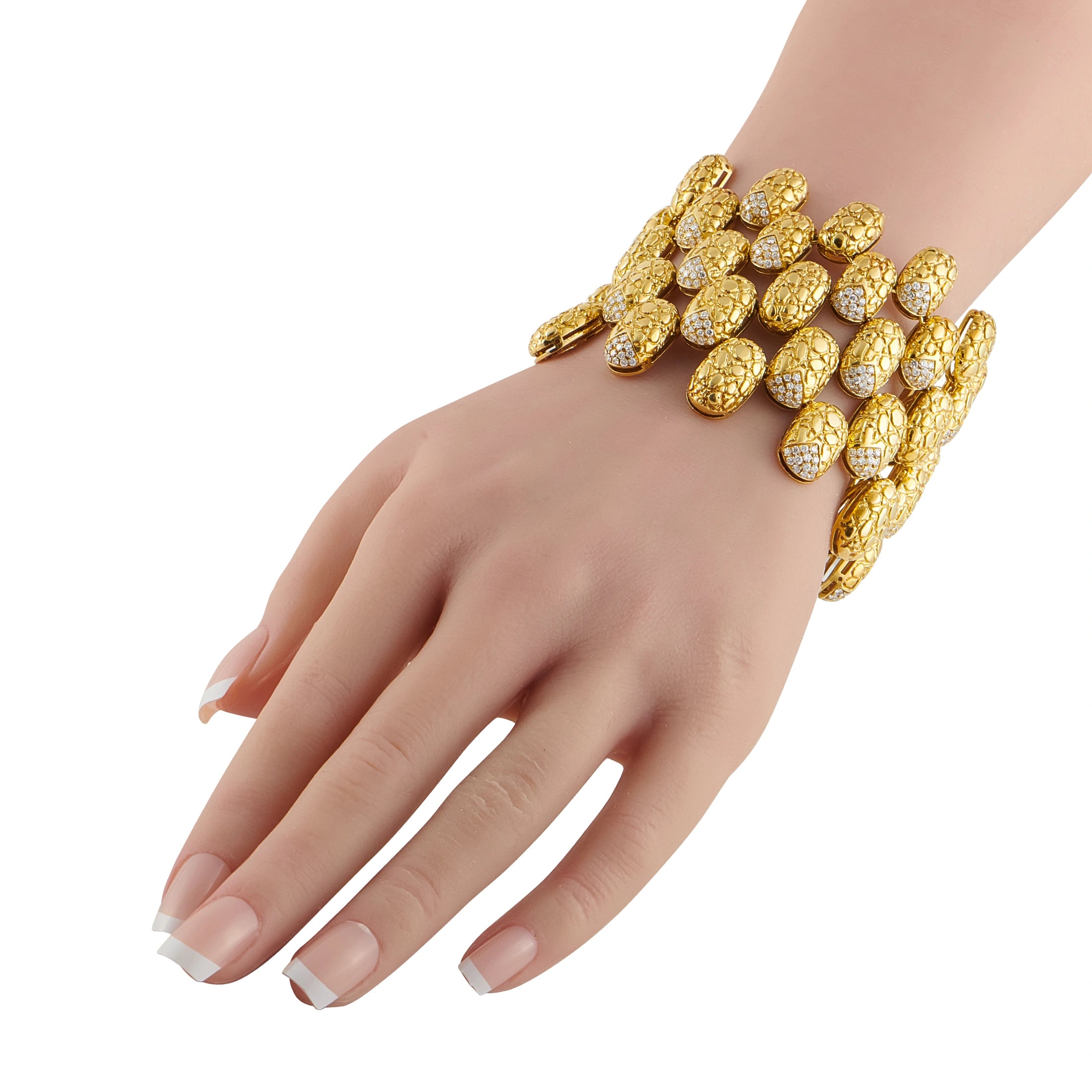 Gold diamond bracelet on wrist with oval textured links