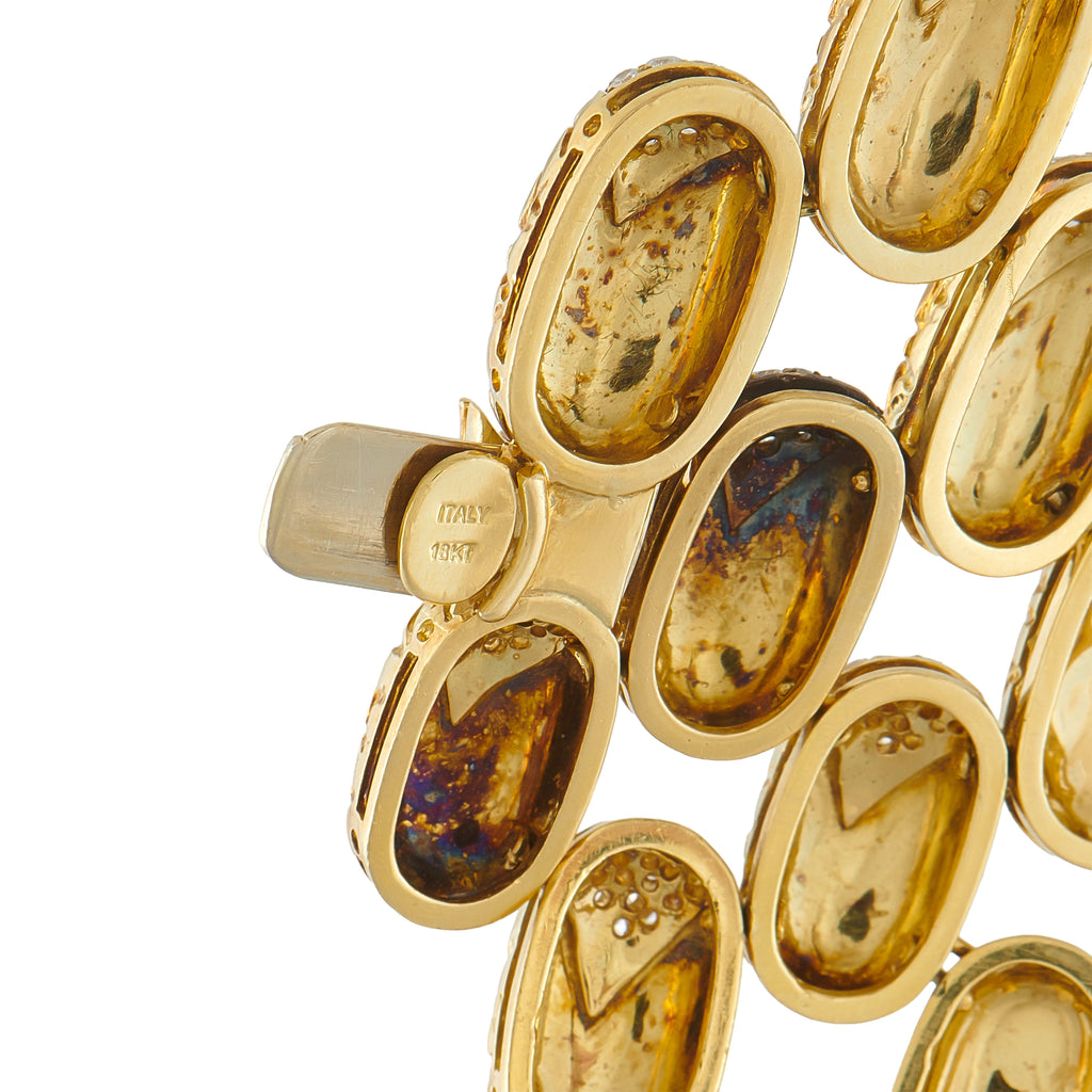 Gucci gold bracelet links with oval shapes, dark insets, and engraved stamp
