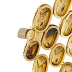 Gucci gold bracelet links with oval shapes, dark insets, and engraved stamp
