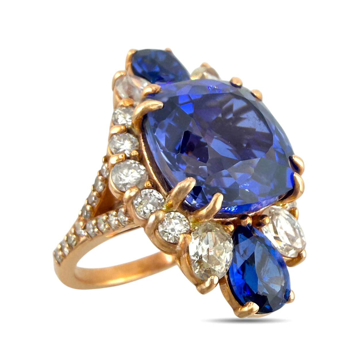 Rose gold ring with large oval blue sapphire and diamond cluster settings, prong-set