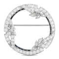 Round platinum brooch with diamond pave setting and dark sapphire accents