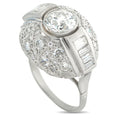 Diamond ring with round center stone, baguette side accents, and pave band in white metal