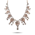 Rose gold diamond necklace with heart-shaped filigree and dangling floral details