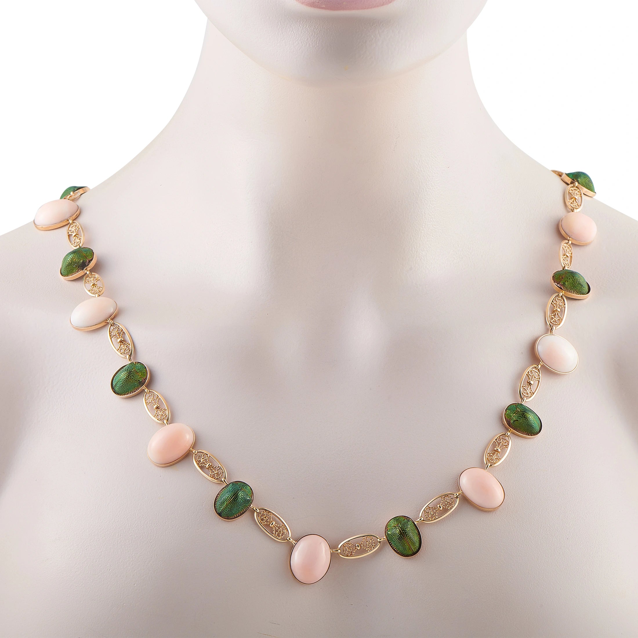 Rose gold tone necklace on mannequin with green and pink oval cabochons and ornate links