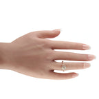 Oval diamond halo ring in 14K rose gold worn on a hand with manicured nails