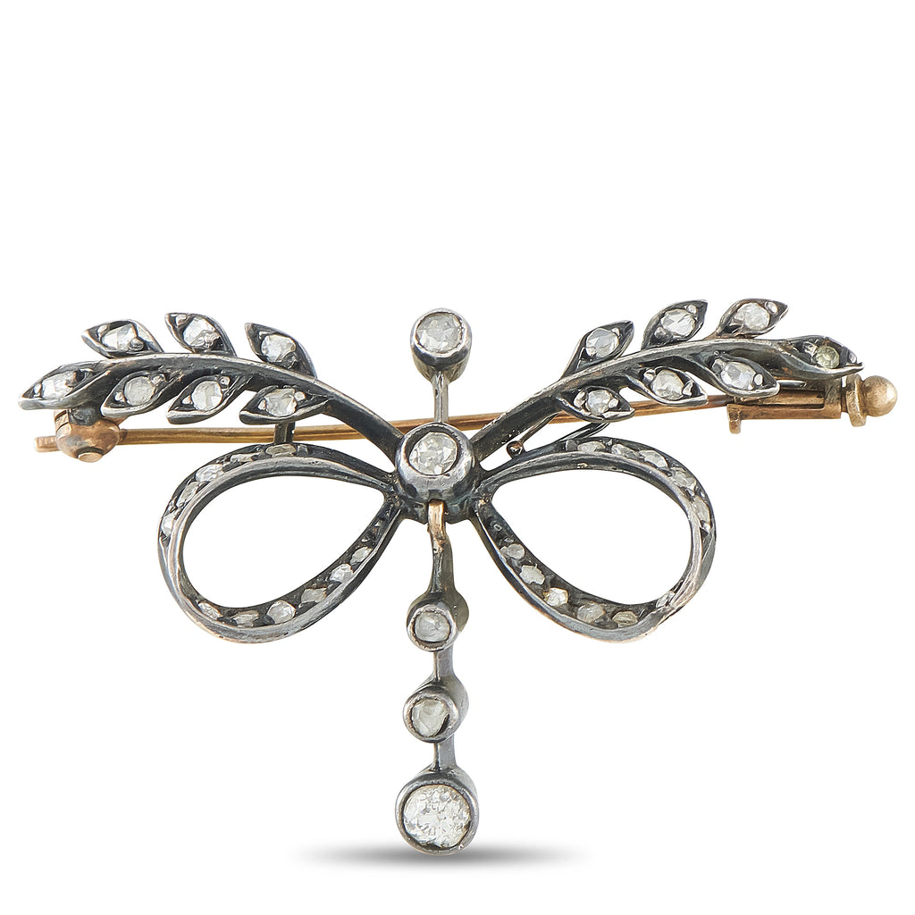 Diamond bow brooch with openwork metal, oval loops and dangling round stones
