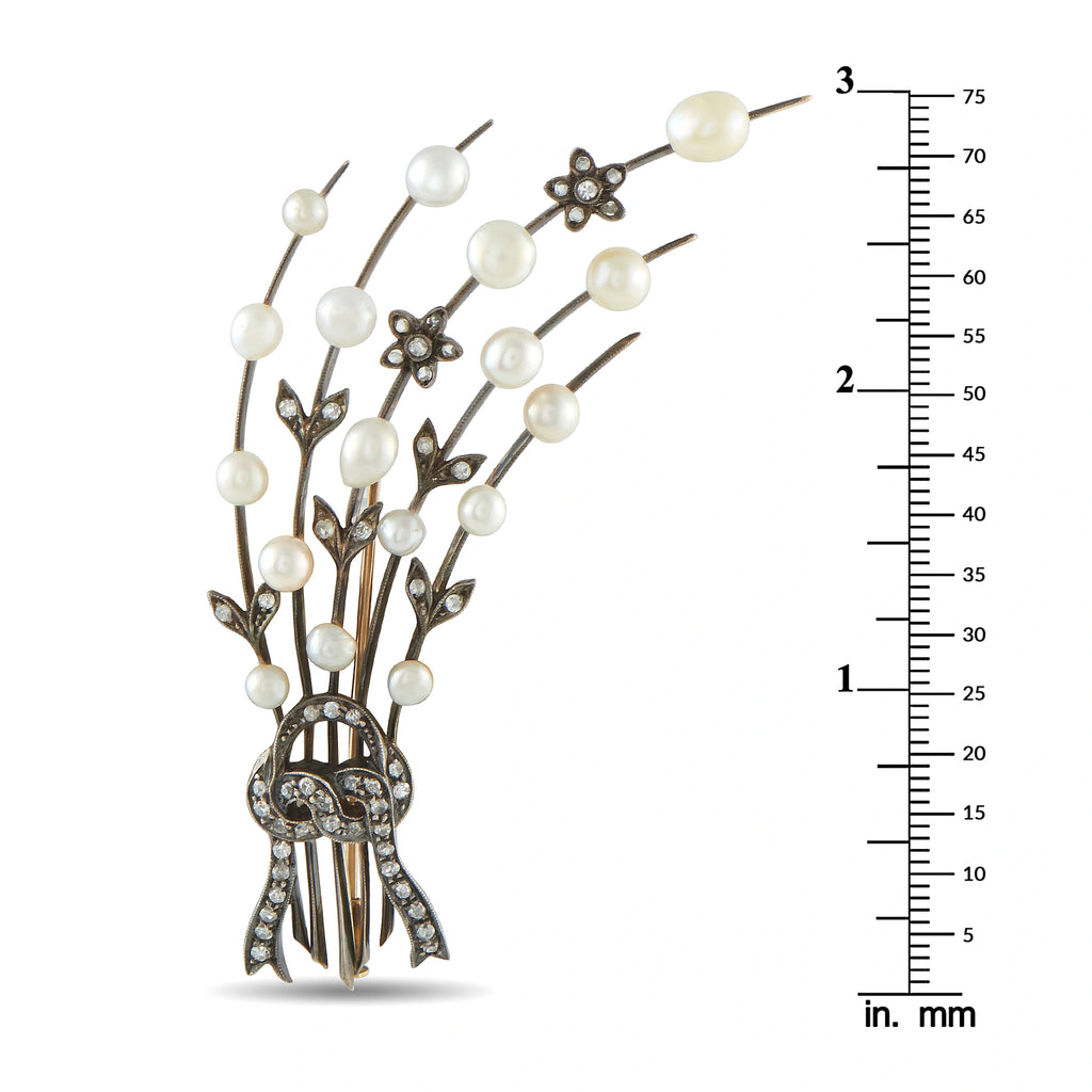 Antique spray brooch with pearls and diamond accents, shown next to size ruler