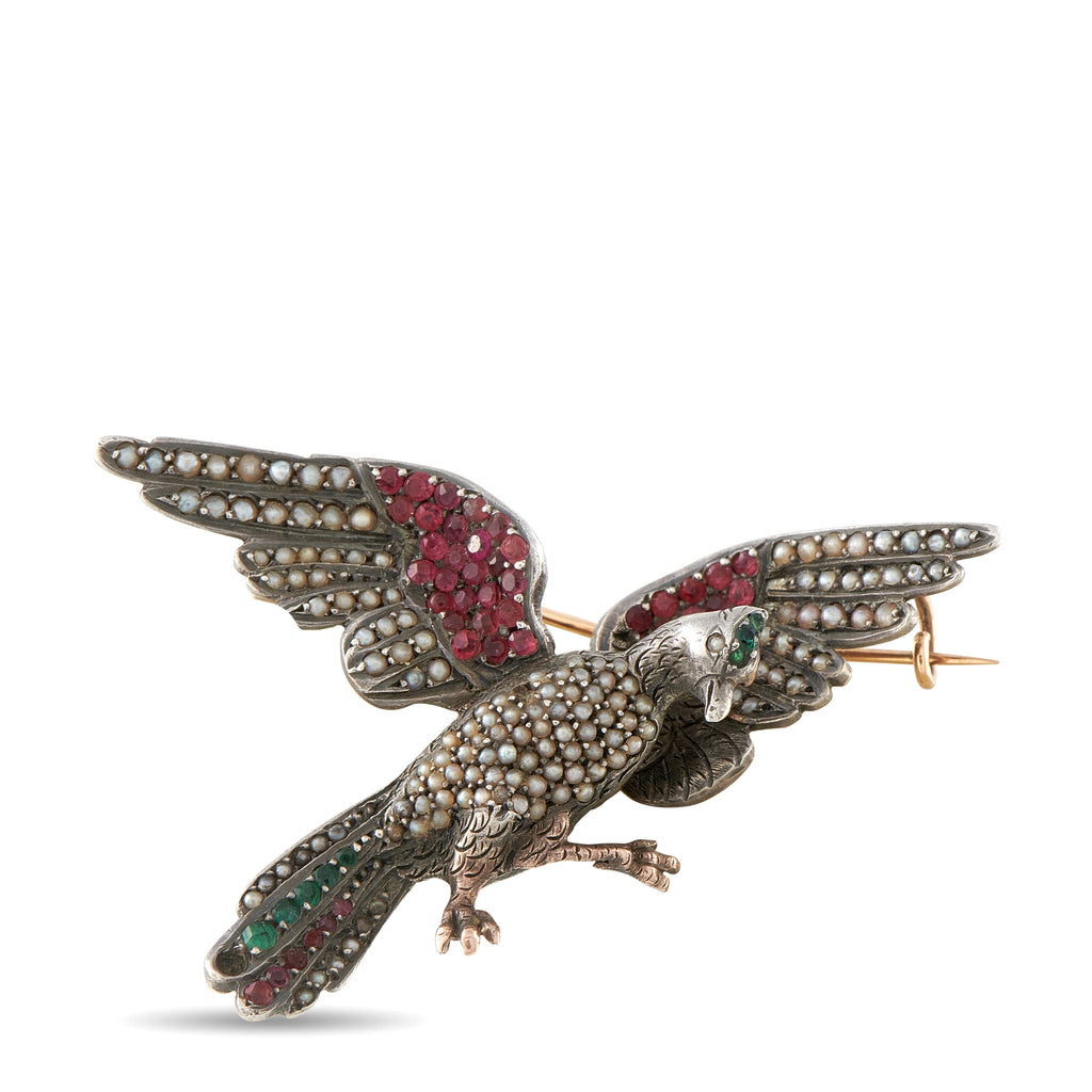 Antique bird brooch in gold-tone with red and green gemstone accents, detailed wings